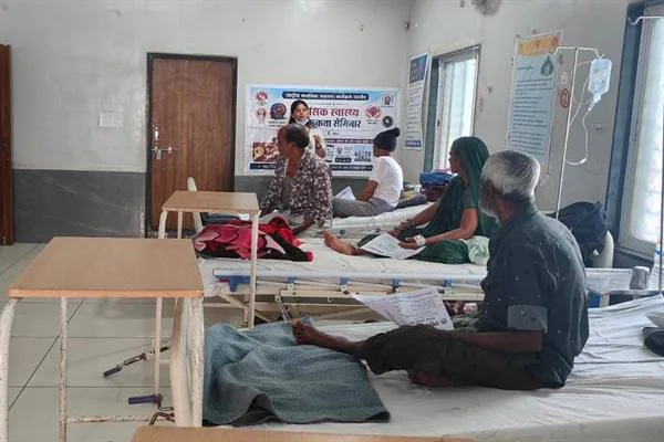 अस्पताल के वृद्धजन वार्ड में बिस्तरों पर बैठे मरीज और परिजन जागरूकता कार्यक्रम में जानकारी सुनते हुए